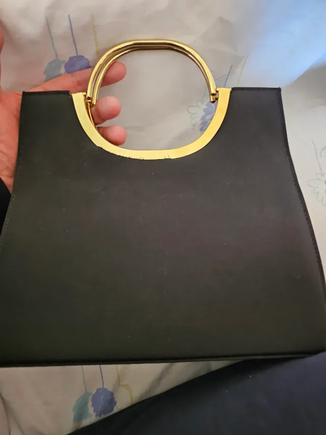 Bolso negro y dorado con asa metálica