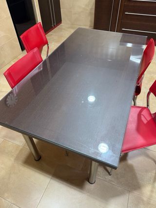 Mesa de comedor con 4 sillas rojas.