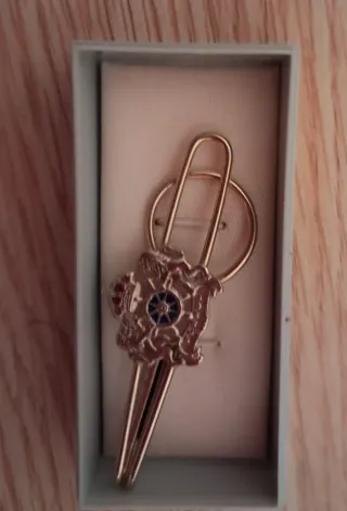 Clip de corbata dorado con detalle azul