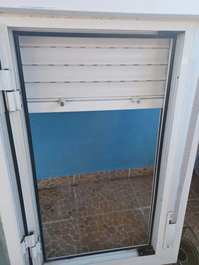 Ventana blanca con persiana