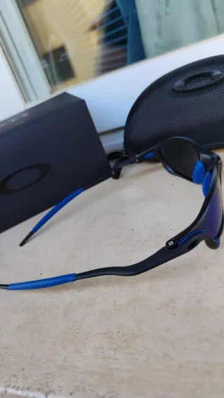 Gafas de sol Oakley negras y azules con accesorios