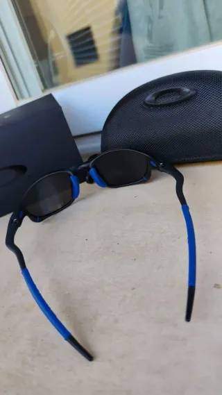 Gafas de sol Oakley negras y azules con accesorios