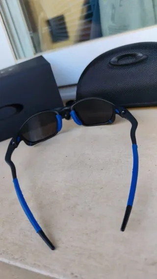 Gafas de sol Oakley negras y azules con accesorios