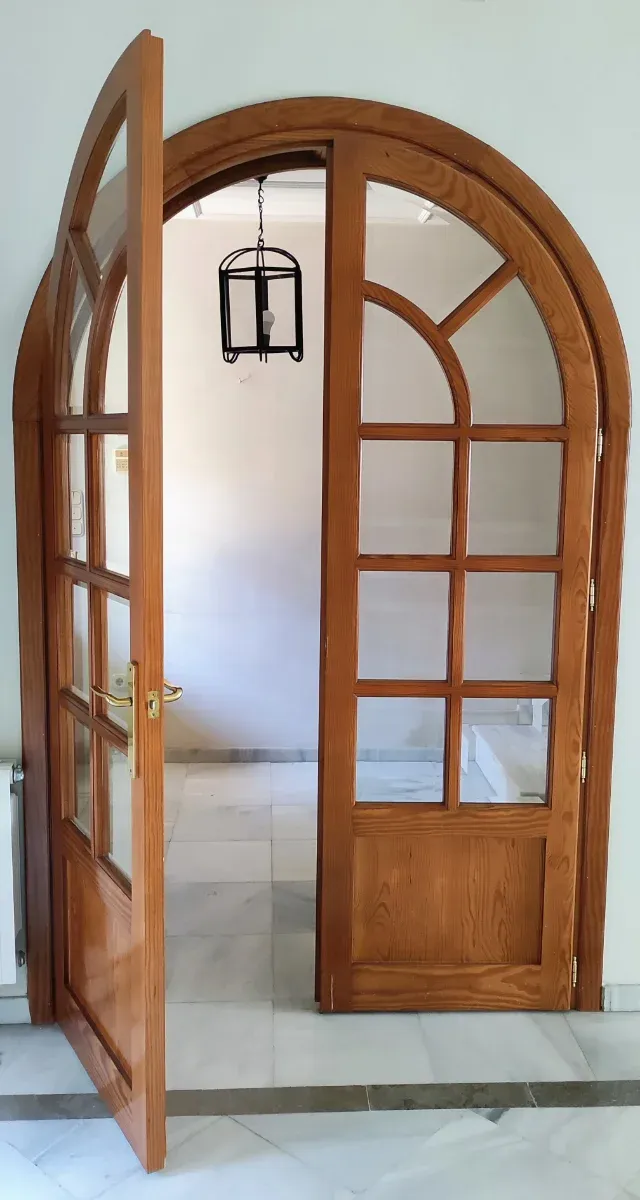 Puerta de madera con arco de medio punto y cristal