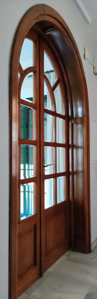 Puerta de madera con arco de medio punto y cristal