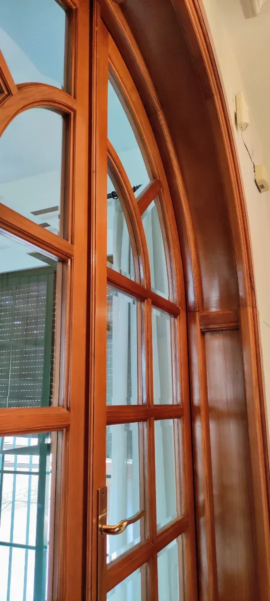 Puerta de madera con arco de medio punto y cristal