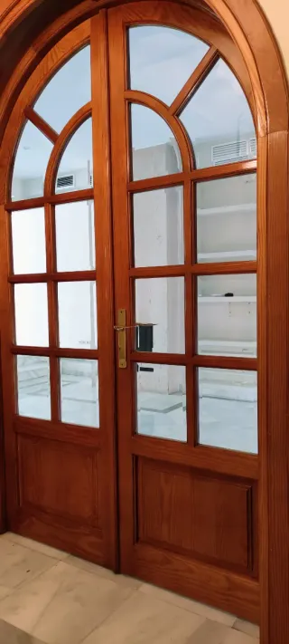 Puerta de madera con arco de medio punto y cristal