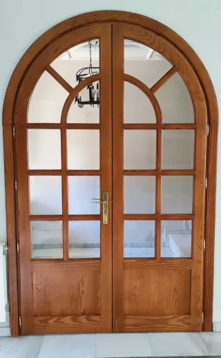 Puerta de madera con arco de medio punto y cristal