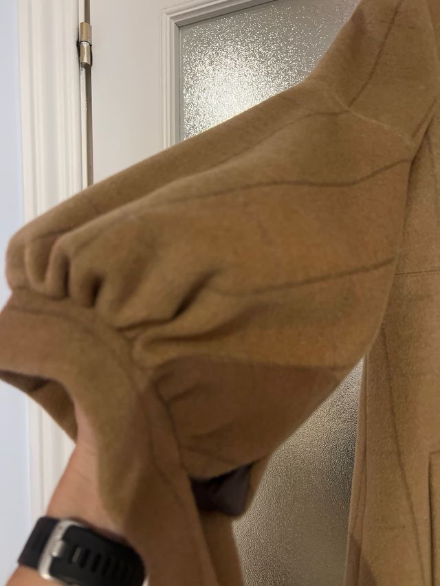 Abrigo beige con botones y mangas abullonadas