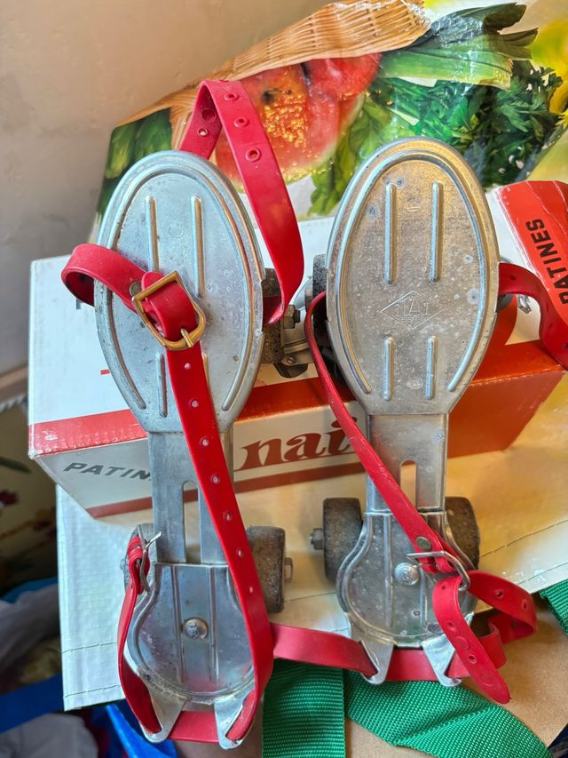 Patines antiguos de metal con correas rojas