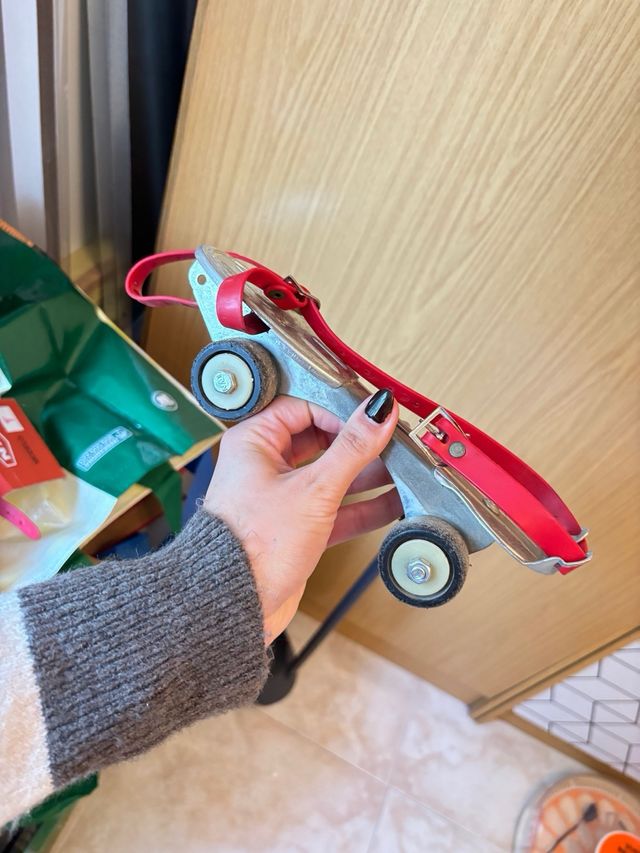 Patines antiguos de metal con correas rojas