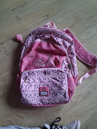 Mochila escolar rosa con diseño de una bicicleta.