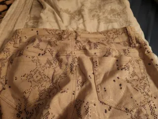 Pantalón beige con estampado dorado