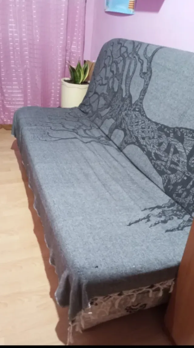 Sofá cama gris con estampado de árbol