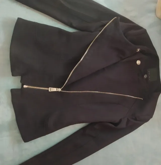 Chaqueta negra con cremallera dorada