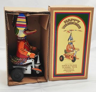 Anatra di latta a molla su triciclo