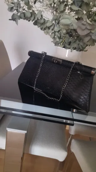 Bolso de mano con cadena.