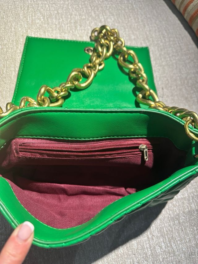 Bolso verde acolchado con cadena dorada.