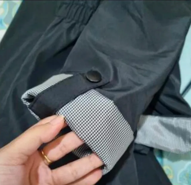 Abrigo negro con mangas enrolladas