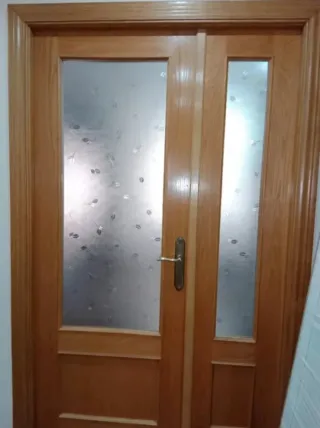 Puerta doble de madera con cristal.