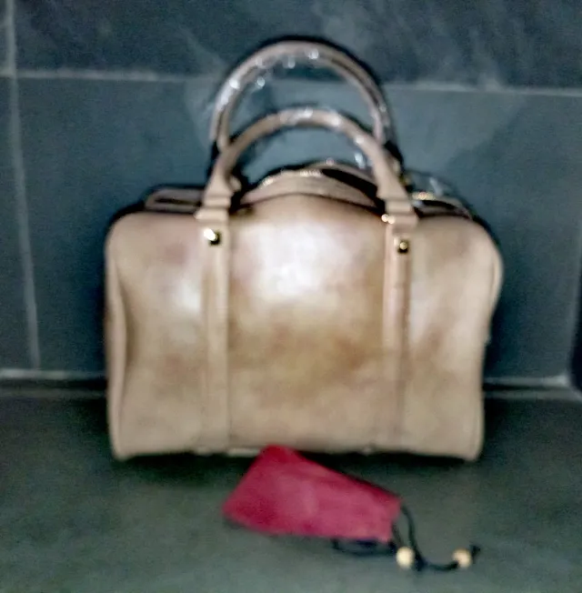 Bolso beige y reloj dorado