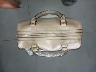 Bolso beige y reloj dorado