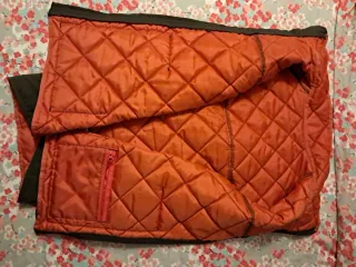 Chaleco acolchado verde con forro naranja