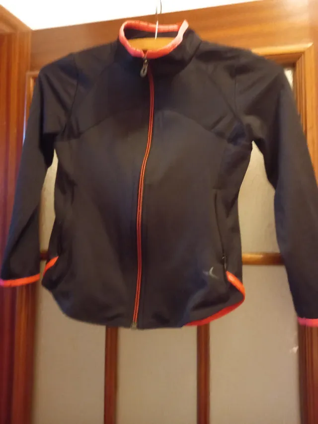 Chaqueta deportiva negra con detalles naranjas