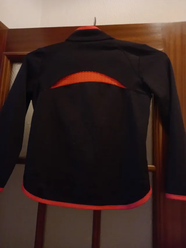 Chaqueta deportiva negra con detalles naranjas