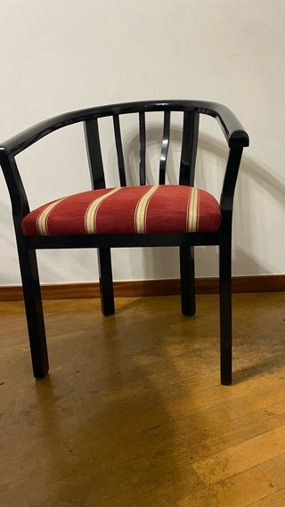 Silla de madera negra con cojín tapizado rojo