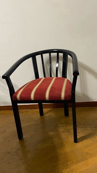 Silla de madera negra con cojín tapizado rojo