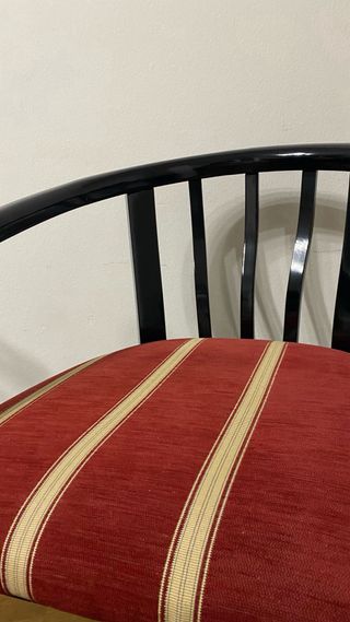 Silla de madera negra con cojín tapizado rojo