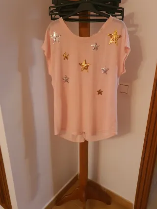 Camiseta rosa con estrellas doradas y plateadas