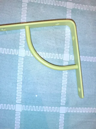 Soportes en L para estanterías metálicas verdes.