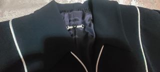 Traje chaqueta y pantalón negro con vivos blancos