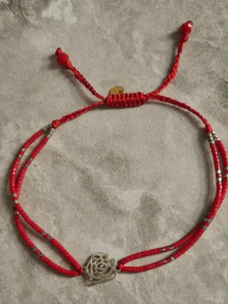 Pulsera roja con detalle de flor de plata