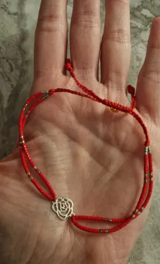Pulsera roja con detalle de flor de plata