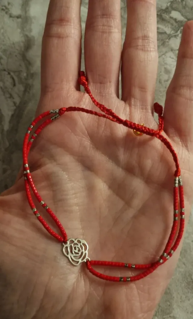 Pulsera roja con detalle de flor de plata