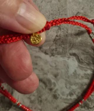 Pulsera roja con detalle de flor de plata