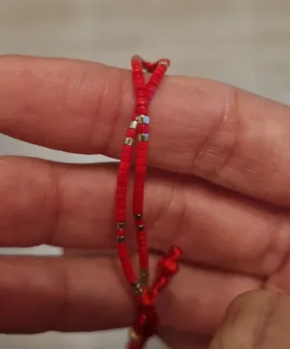 Pulsera roja con detalle de flor de plata