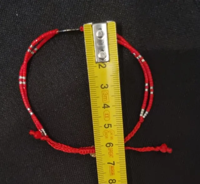 Pulsera roja con detalle de flor de plata