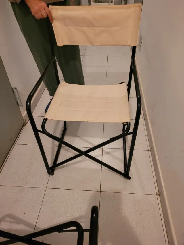 Sillas tipo director beige y negras.