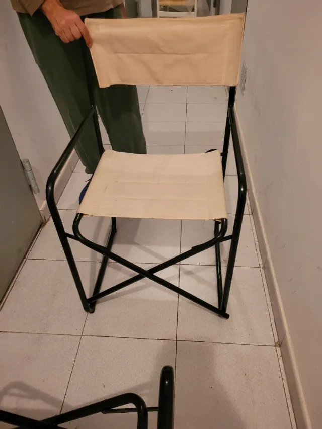 Sillas tipo director beige y negras.