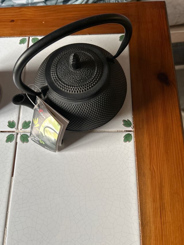 Tetera de hierro fundido negra y cafetera morada