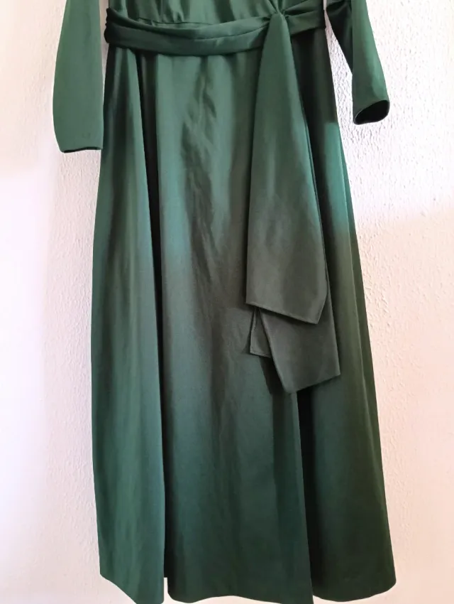 Vestido largo verde oscuro cruzado con cinturón.