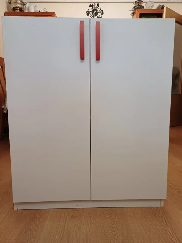 Mueble blanco con tiradores rojos