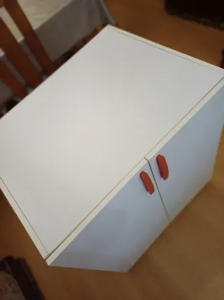 Mueble blanco con tiradores rojos