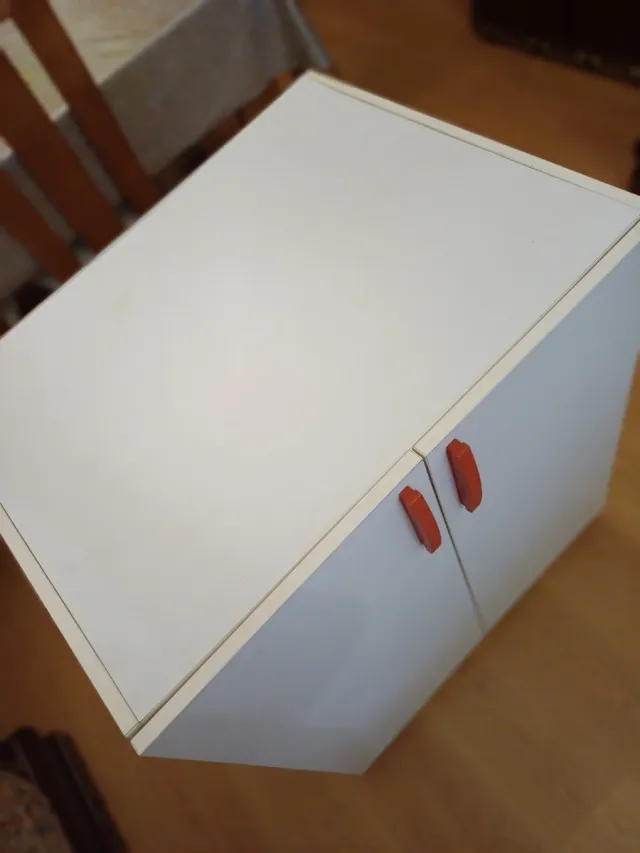 Mueble blanco con tiradores rojos