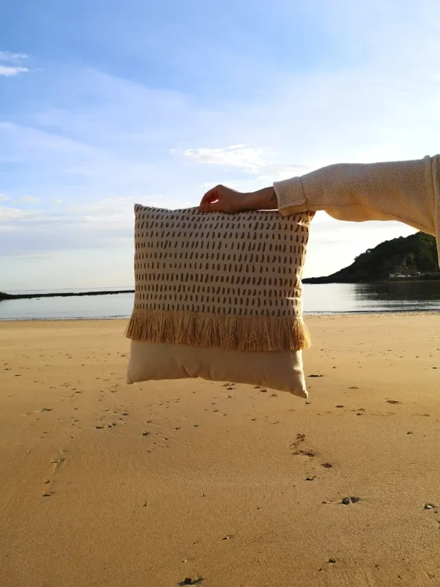 Almofada bege com franjas de ráfia