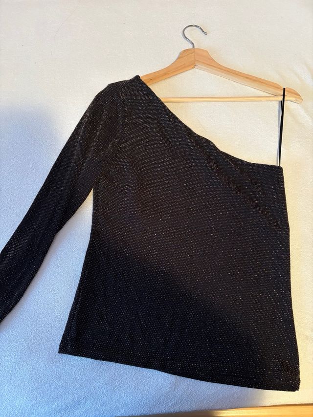 Top asimétrico negro con brillos dorados